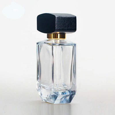 Empty glass perfume bottle with cap and pump spray collarwith wooden black cap