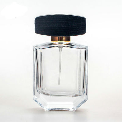 Empty glass perfume bottle with cap and pump spray collarwith wooden black cap